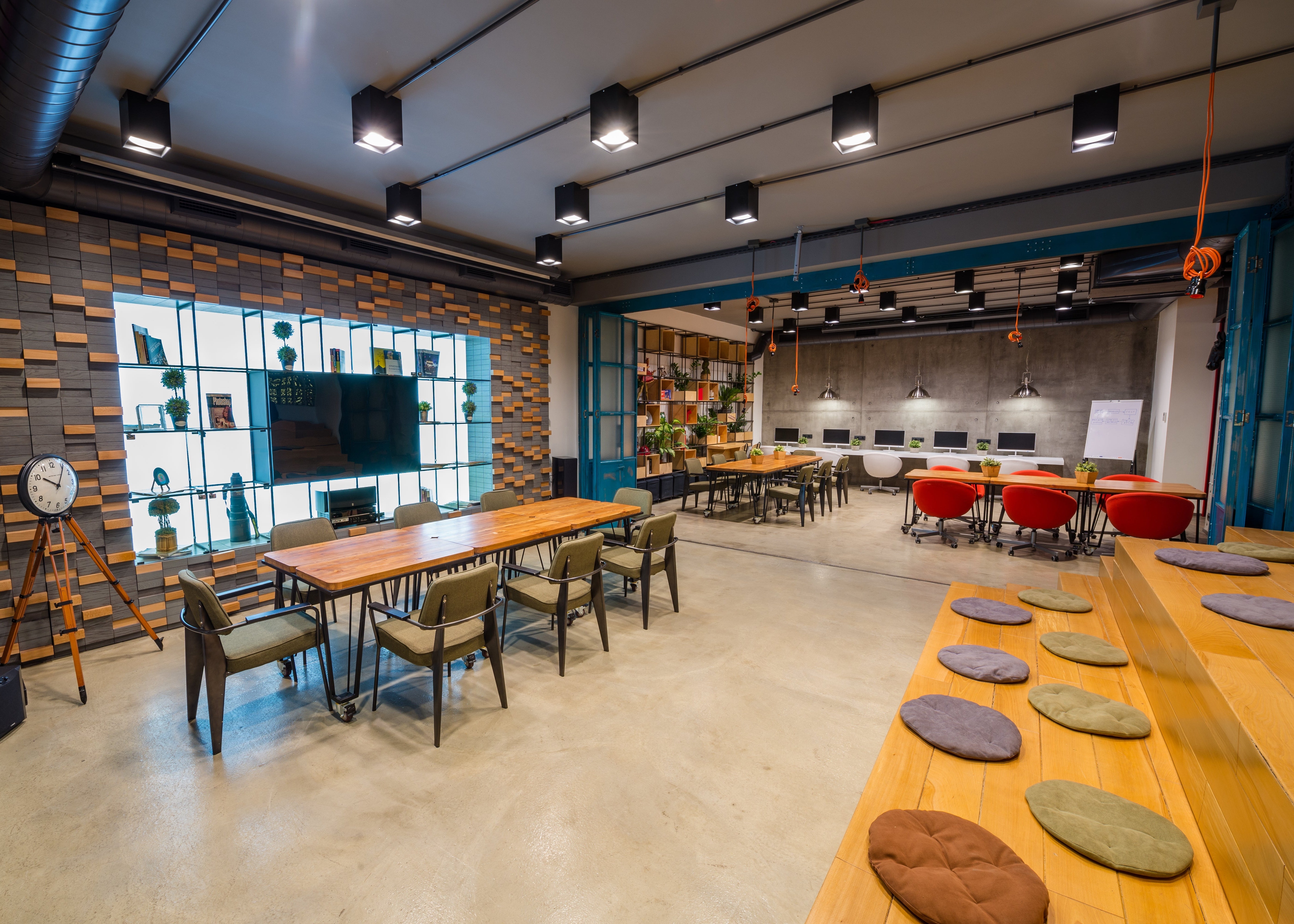 Espace collaboratif avec tables de réunion, comptoir partagé et décoration industrielle. Renobat aménage vos locaux associatifs, espaces de coworking et lieux collectifs à Paris et Île-de-France.