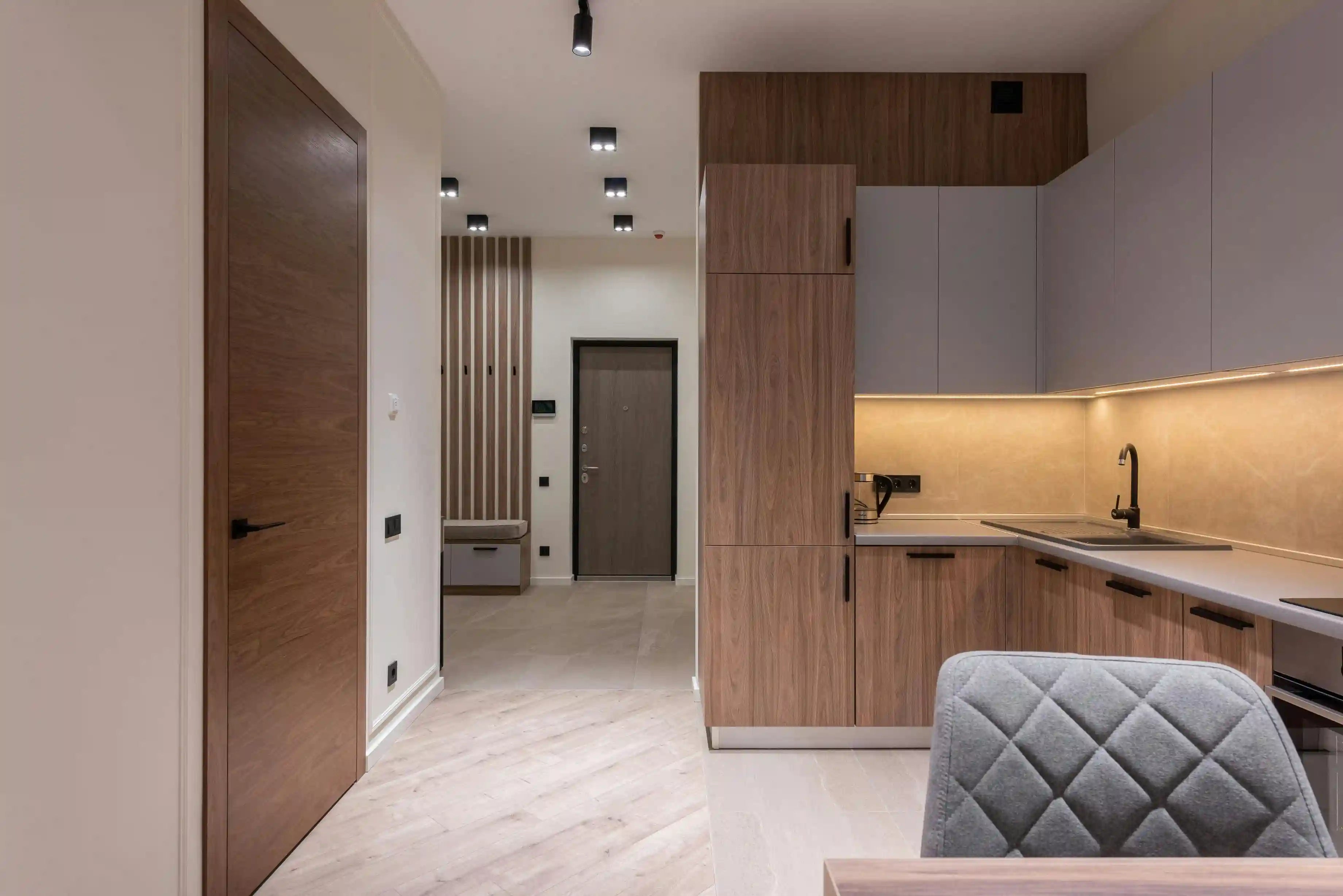 Carrelage sol grand format effet marbre blanc dans un espace de vie moderne. Pose rectifiée avec joints fins créant une surface continue et élégante, parfaite pour les cuisines ouvertes et espaces contemporains.