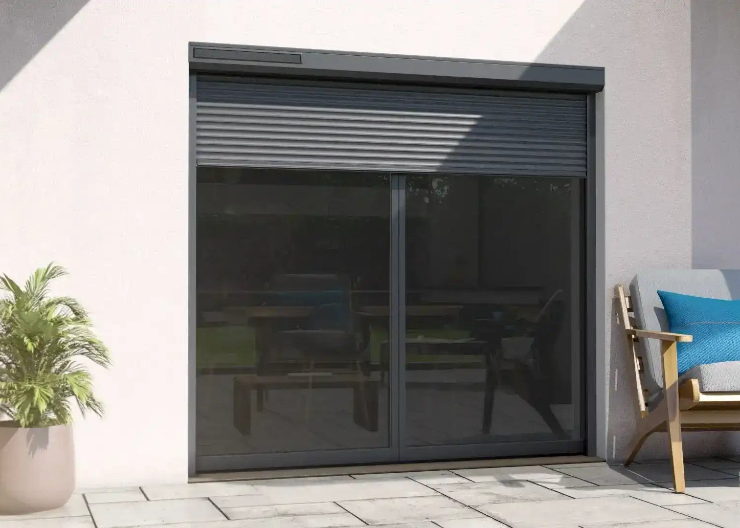 Volet roulant gris partiellement fermé sur baie vitrée moderne avec terrasse et fauteuil extérieur